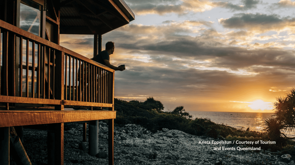 Guest watching sunrise from a Camp Island Lodge deck in the Whitsundays Queensland